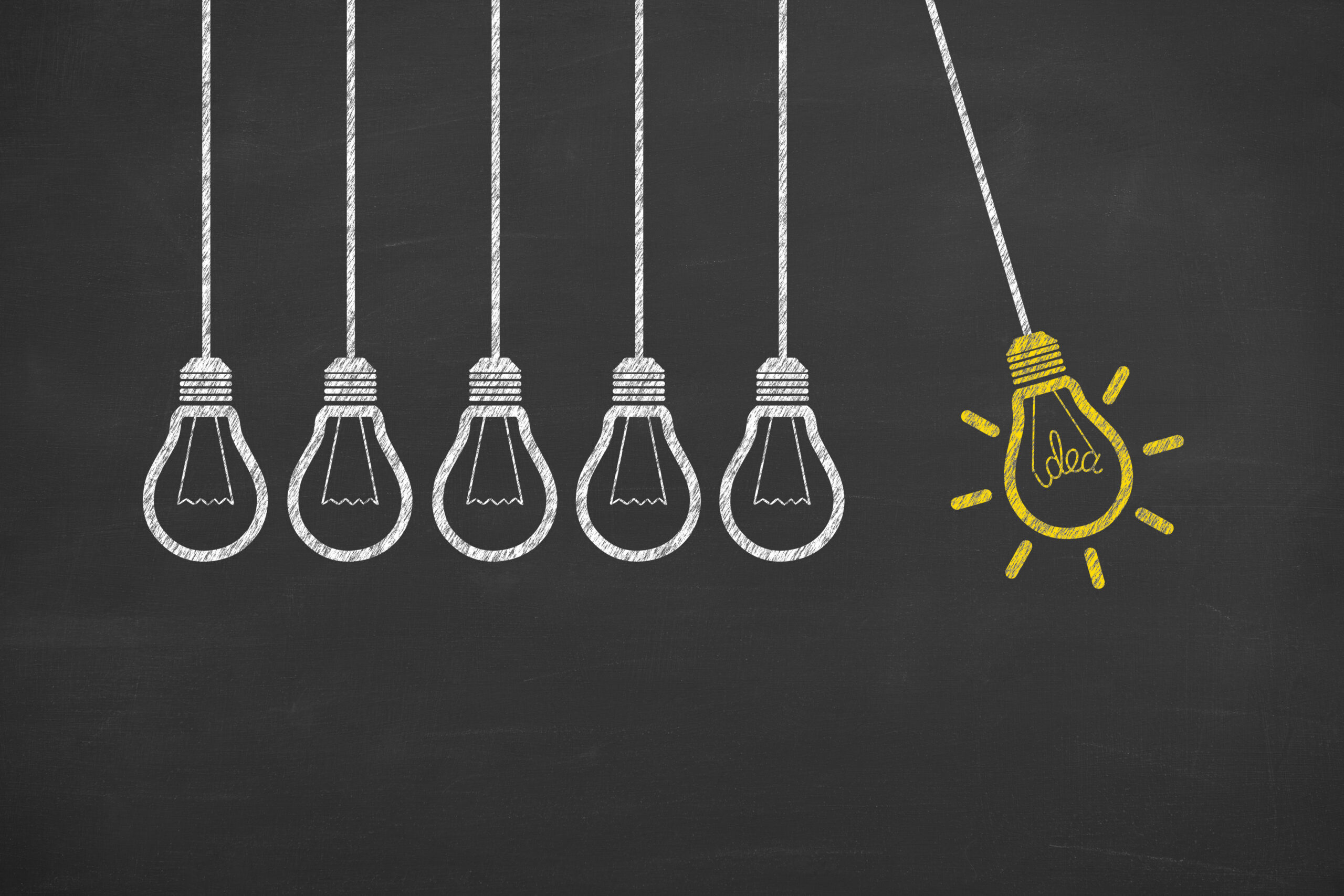 Glowing Light Bulb Innovation Concept on Chalkboard